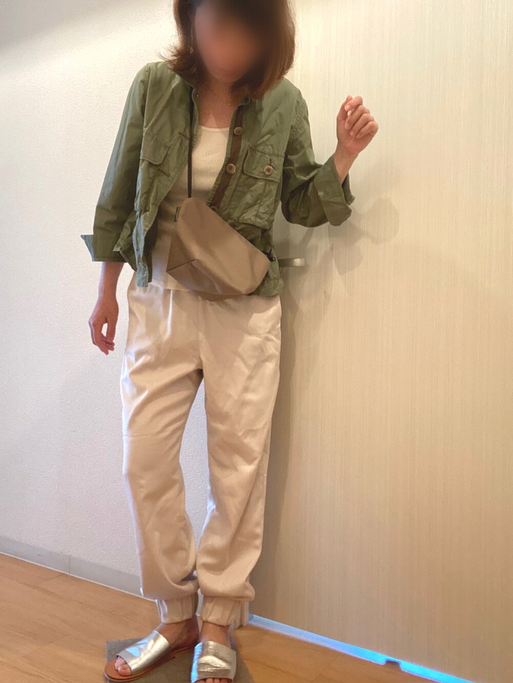 グリーン系のミリタリージャケット、ホワイト系のその他パンツ、シルバー系のサンダルを着用したレディースの春コーディネートの2枚目の写真