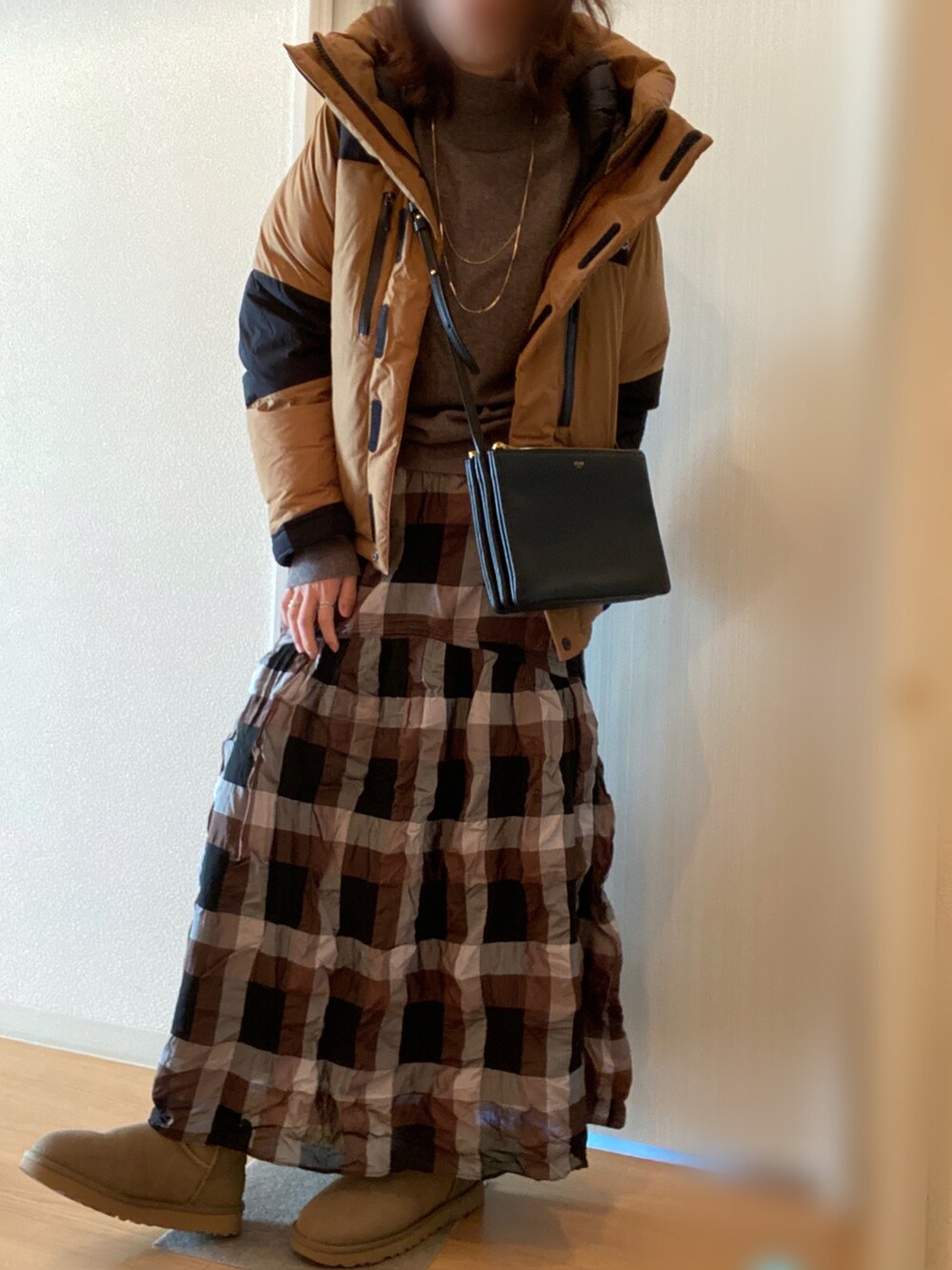 ベージュ系のダウンジャケット/コート、ベージュ系のニット/セーター、ブラック系のスカートを着用したレディースの冬コーディネートの3枚目の写真