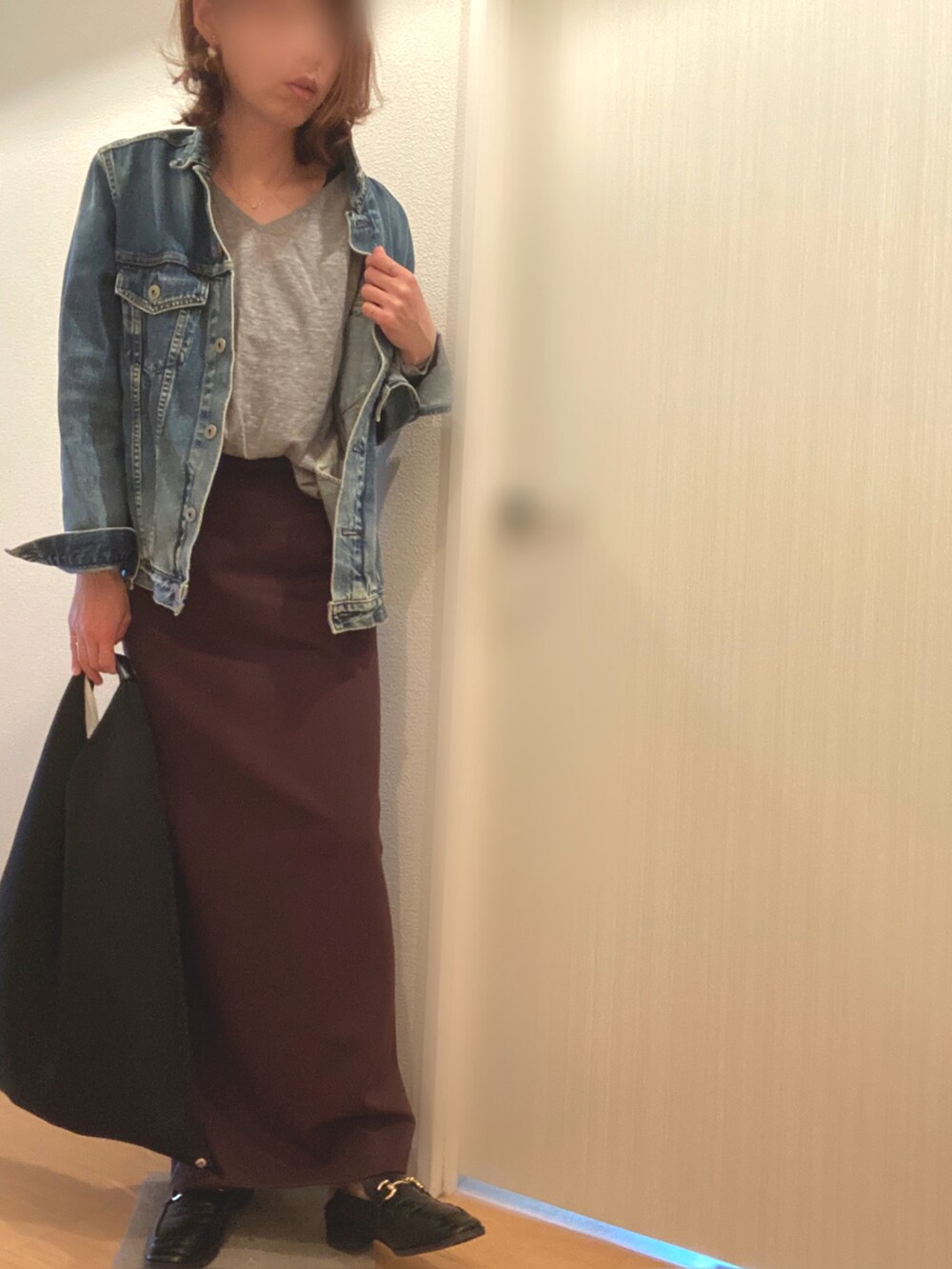 ブルー系のデニムジャケット、グレー系のニット/セーター、ブラウン系のスカートを着用したレディースの春コーディネートの3枚目の写真