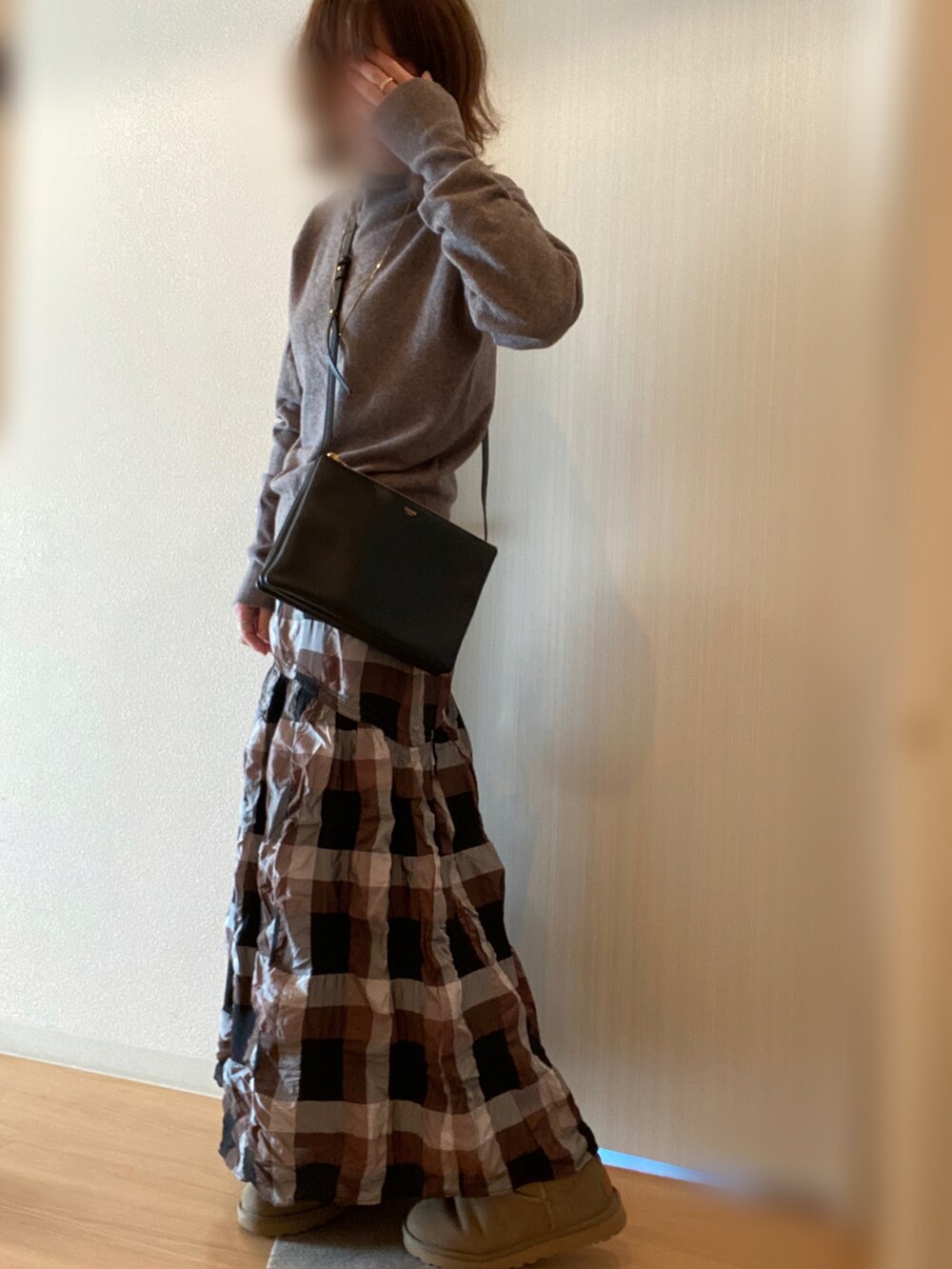 ベージュ系のダウンジャケット/コート、ベージュ系のニット/セーター、ブラック系のスカートを着用したレディースの冬コーディネートの5枚目の写真