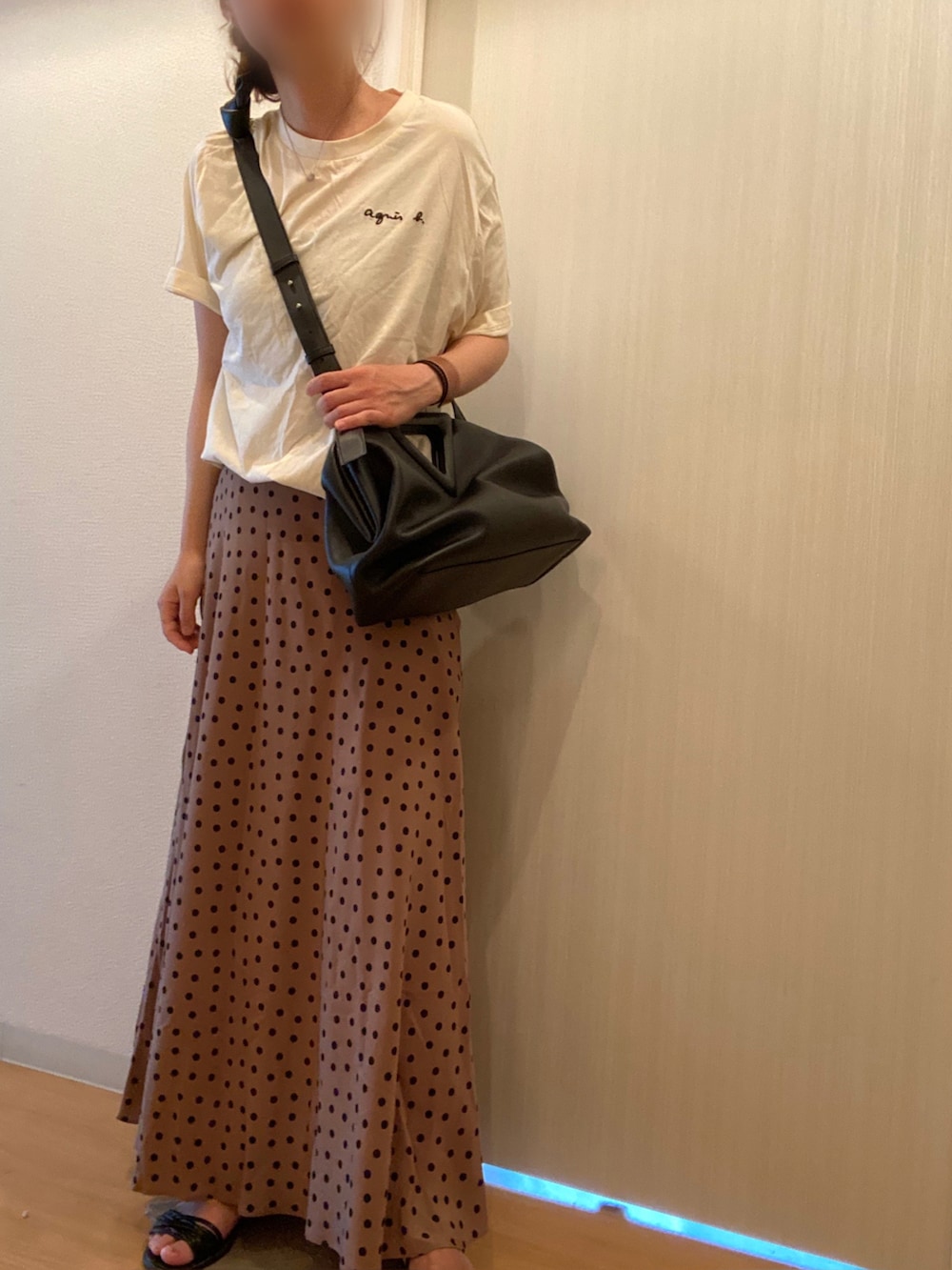 ホワイト系のTシャツ/カットソー、ベージュ系のスカート、ブラック系のサンダルを着用したレディースの夏コーディネートの2枚目の写真
