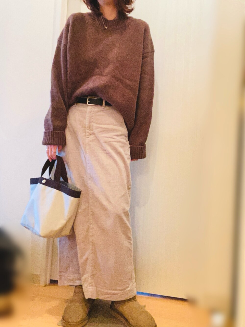 ブラウン系のニット/セーター、グレー系のスカート、グリーン系のブーツを着用したレディースの冬コーディネートの3枚目の写真