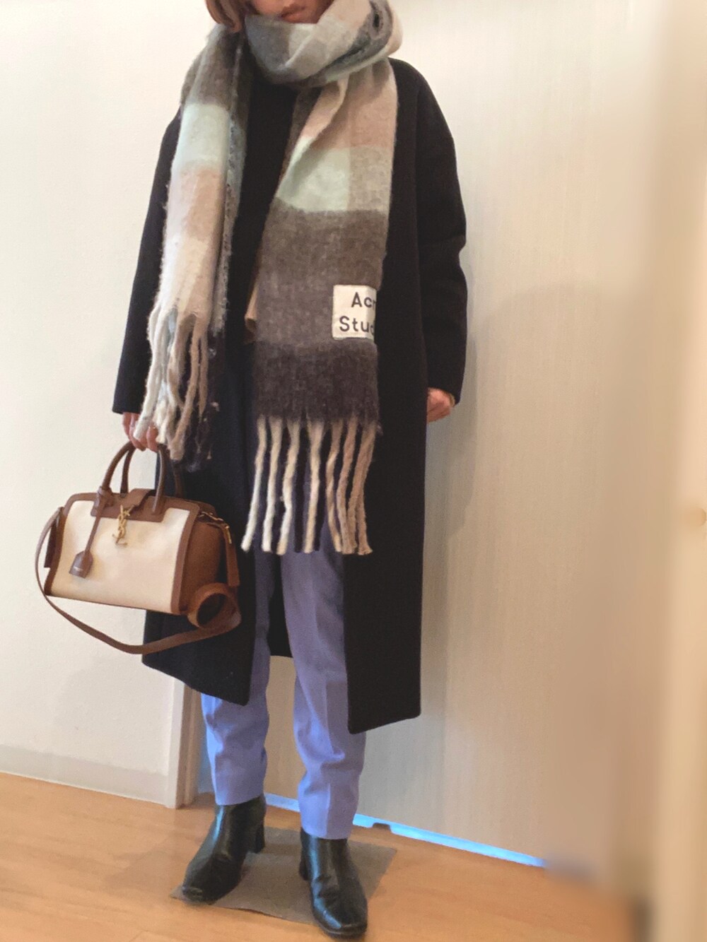 ホワイト系のニット/セーター、ブルー系のその他パンツ、ブラック系のステンカラーコートを着用したレディースの冬コーディネートの2枚目の写真