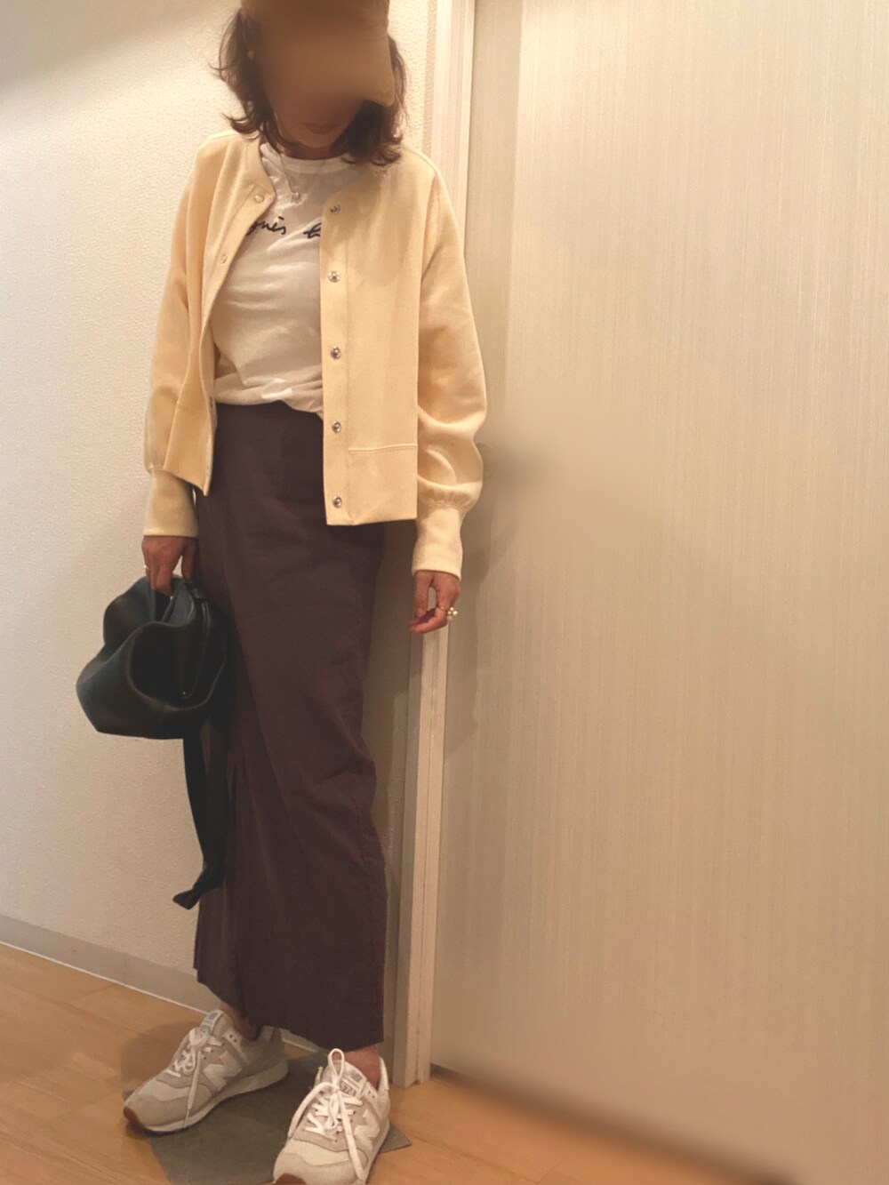 ホワイト系のTシャツ/カットソー、ホワイト系のカーディガン/ボレロ、グレー系のスカートを着用したレディースの春コーディネートの2枚目の写真