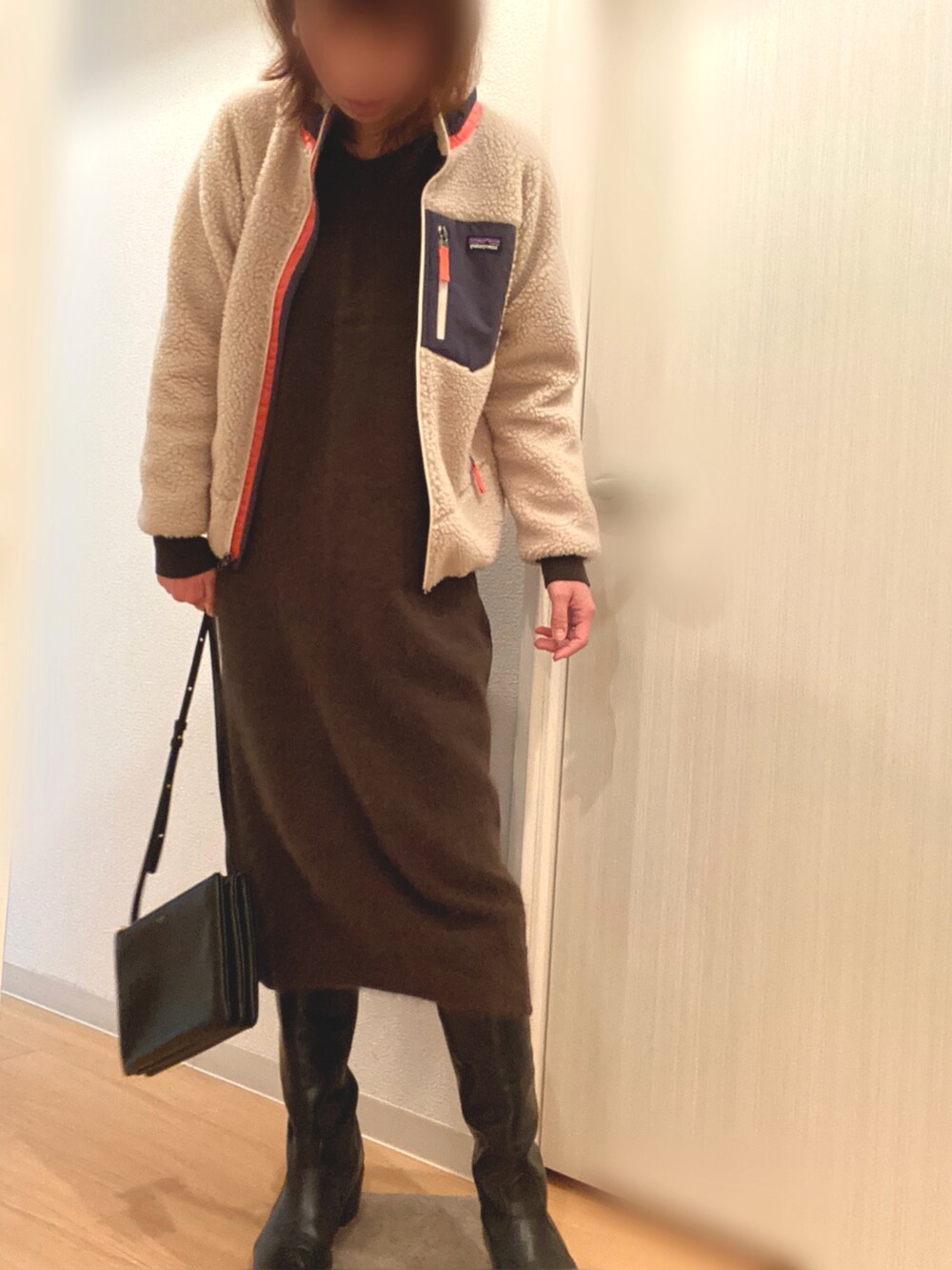 ベージュ系のブルゾン、グリーン系のワンピース、ブラック系のブーツを着用したレディースの冬コーディネートの2枚目の写真