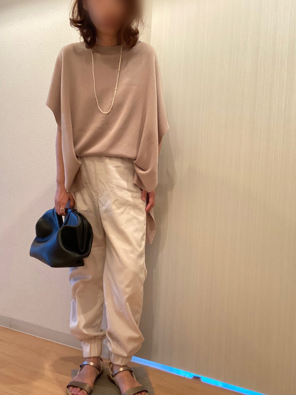 ベージュ系のニット/セーター、ホワイト系のその他パンツ、ベージュ系のサンダルを着用したレディースの夏コーディネートの3枚目の写真