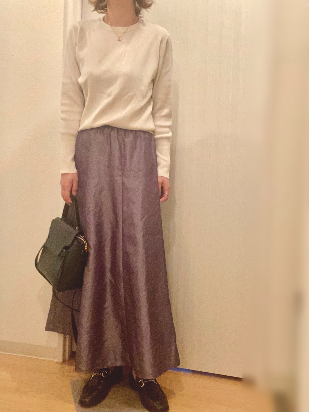 ベージュ系のトレンチコート、ホワイト系のニット/セーター、グレー系のスカートを着用したレディースの春コーディネートの2枚目の写真