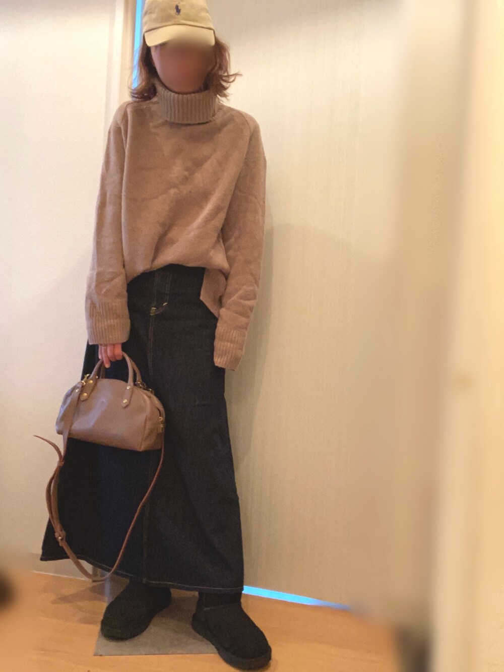 グリーン系のジャケット/アウター、ベージュ系のニット/セーター、ブルー系のデニムスカートを着用したレディースの冬コーディネートの3枚目の写真
