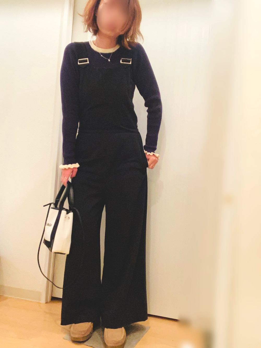 ブラウン系のその他アウター、ブルー系のニット/セーター、ブラック系のサロペット/オーバーオールを着用したレディースの冬コーディネートの2枚目の写真