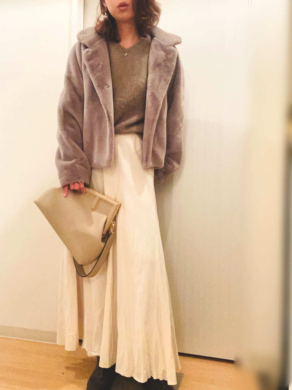 ブラウン系のニット/セーター、ホワイト系のスカート、ブラウン系のその他アウターを着用したレディースの冬コーディネートの2枚目の写真