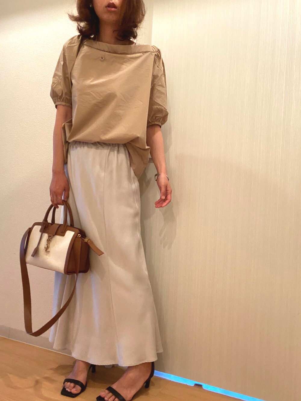 ベージュ系のシャツ/ブラウス、グレー系のスカート、ブラック系のサンダルを着用したレディースの夏コーディネートの2枚目の写真