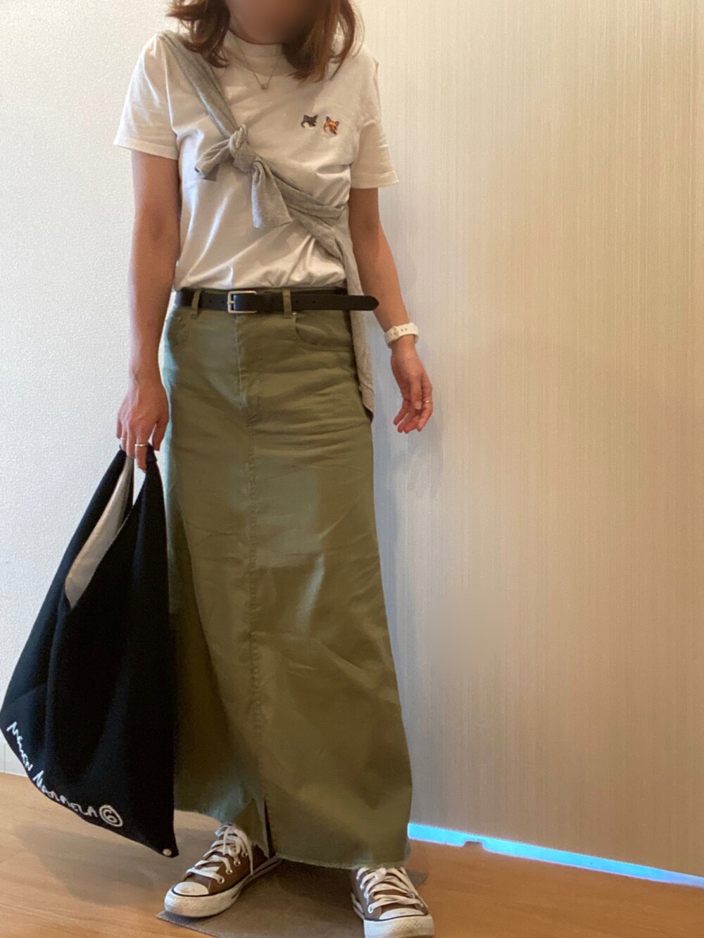ホワイト系のTシャツ/カットソー、グリーン系のスカート、ブラック系のハンドバッグを着用したレディースの秋コーディネートの3枚目の写真