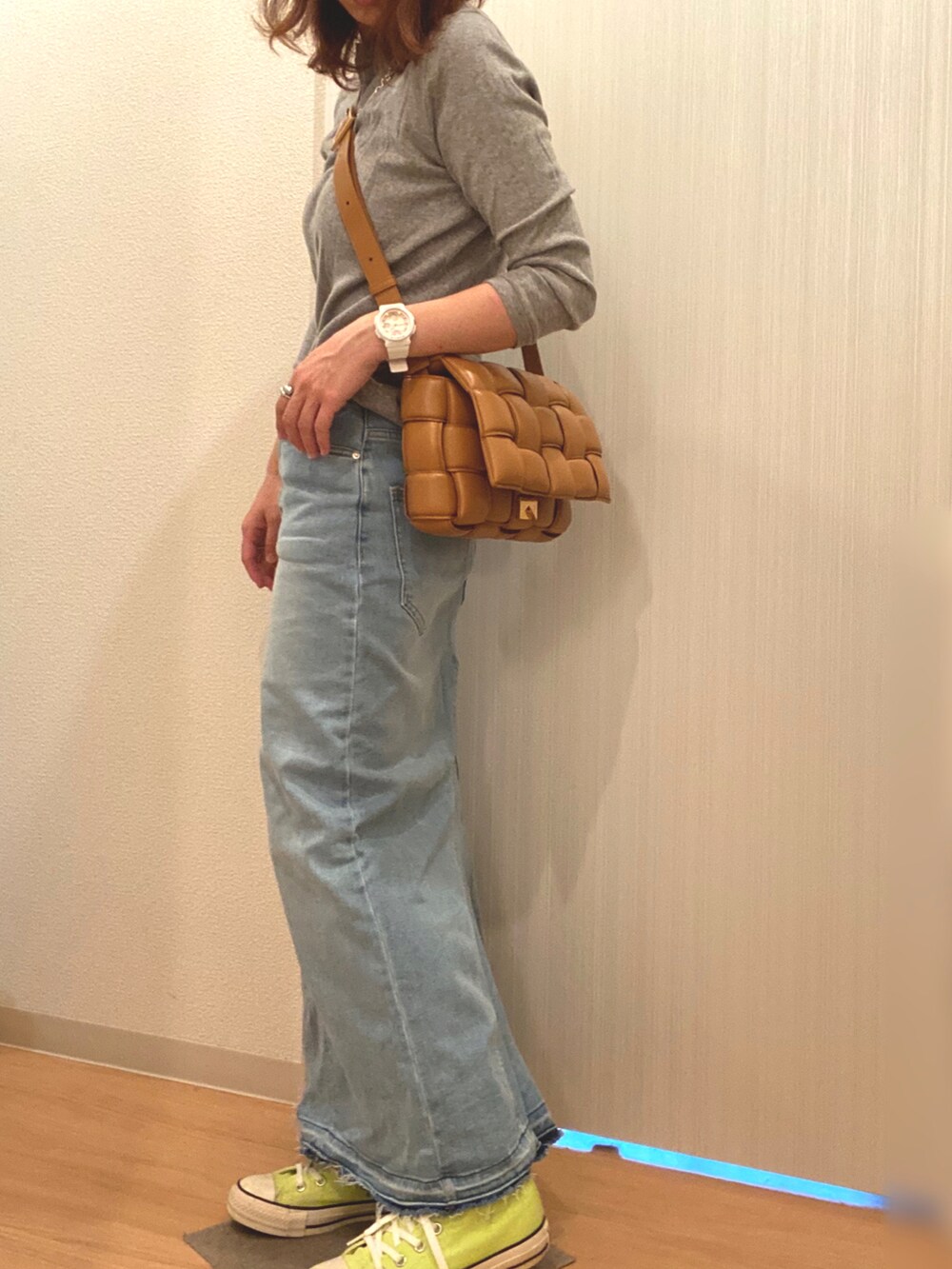 グレー系のTシャツ/カットソー、ブルー系のデニムスカート、イエロー系のスニーカーを着用したレディースの秋コーディネートの2枚目の写真