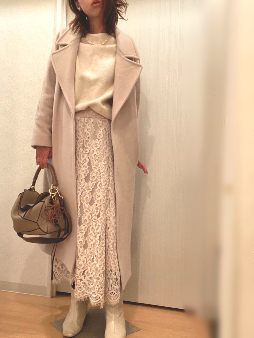 ホワイト系のニット/セーター、ベージュ系のスカート、ベージュ系のその他アウターを着用したレディースの冬コーディネートの2枚目の写真