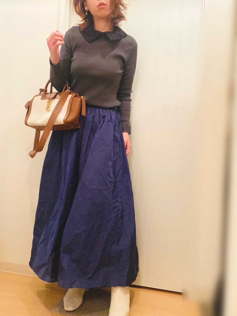 グレー系のニット/セーター、ブルー系のスカート、ベージュ系のブーツを着用したレディースの冬コーディネートの2枚目の写真