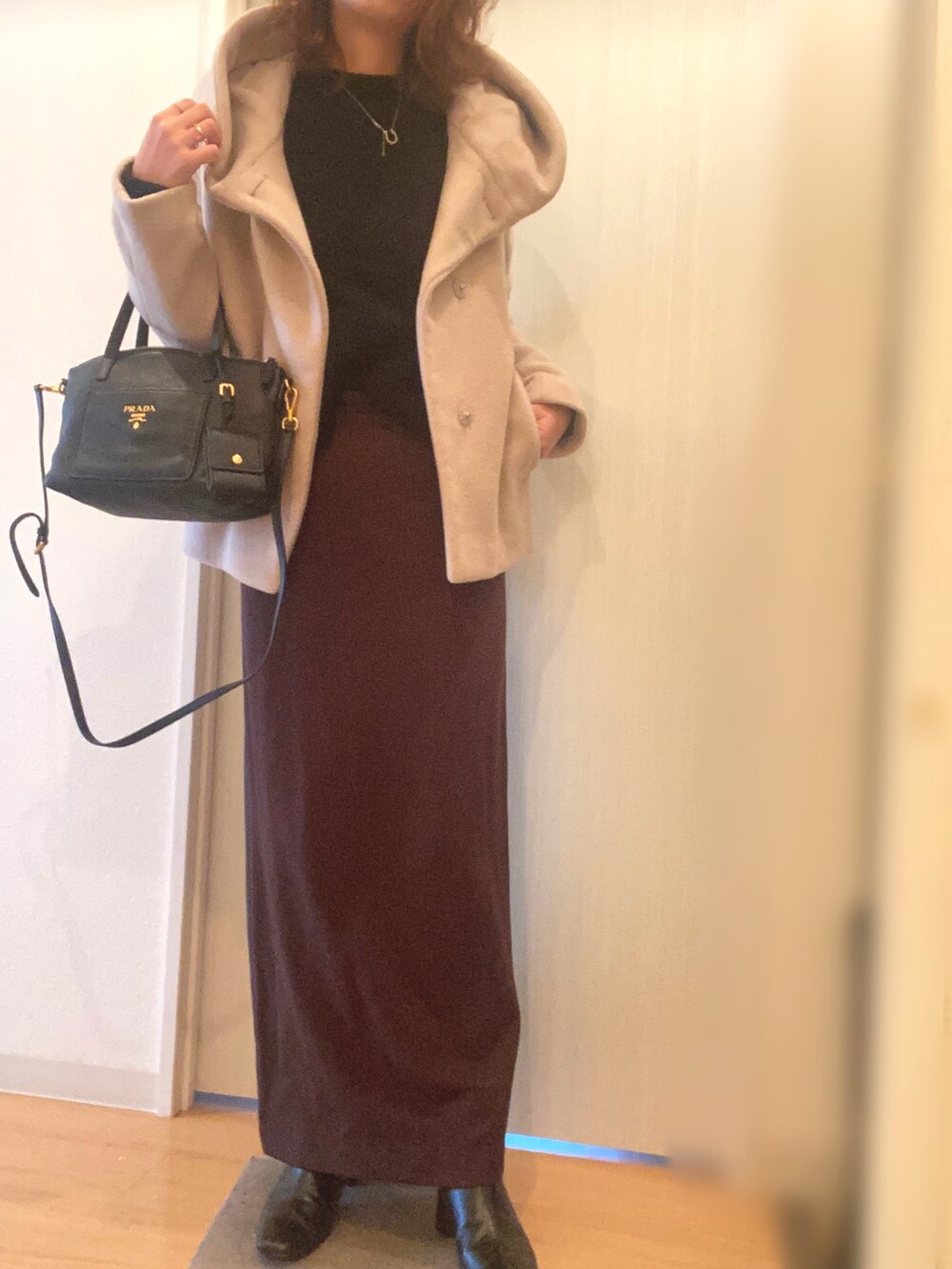 ブラック系のニット/セーター、ブラウン系のスカート、ブラック系のブーツを着用したレディースの冬コーディネートの2枚目の写真