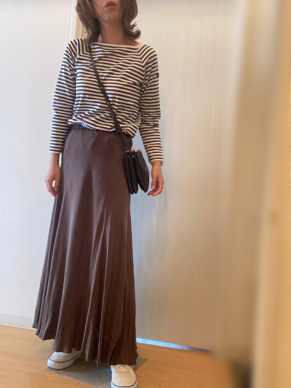 ブラウン系のTシャツ/カットソー、ブラウン系のスカート、ホワイト系のスニーカーを着用したレディースの秋コーディネートの2枚目の写真