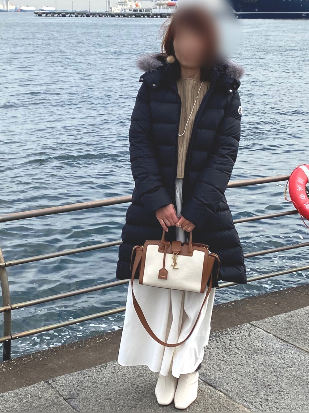 ベージュ系のニット/セーター、ホワイト系のスカート、ホワイト系のブーツを着用したレディースの冬コーディネートの2枚目の写真