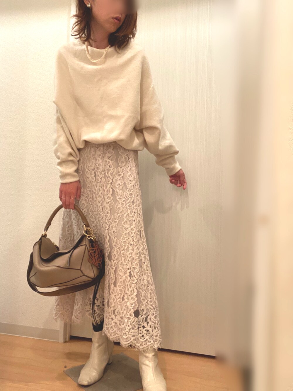 ホワイト系のニット/セーター、ベージュ系のスカート、ベージュ系のその他アウターを着用したレディースの冬コーディネートの3枚目の写真