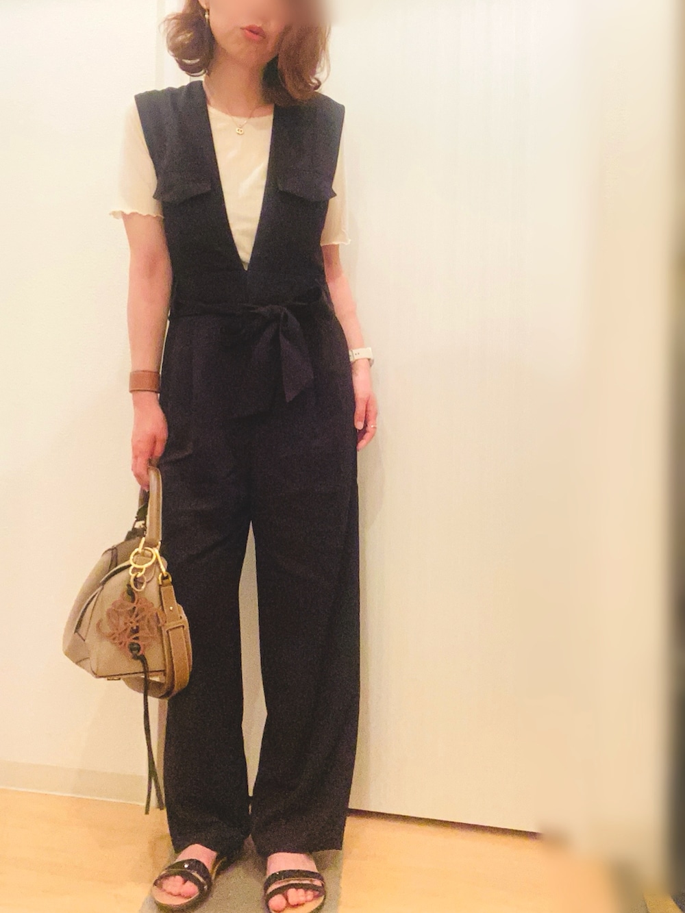 ホワイト系のTシャツ/カットソー、ブラック系のつなぎ/オールインワン、ブラック系のサンダルを着用したレディースの夏コーディネートの2枚目の写真