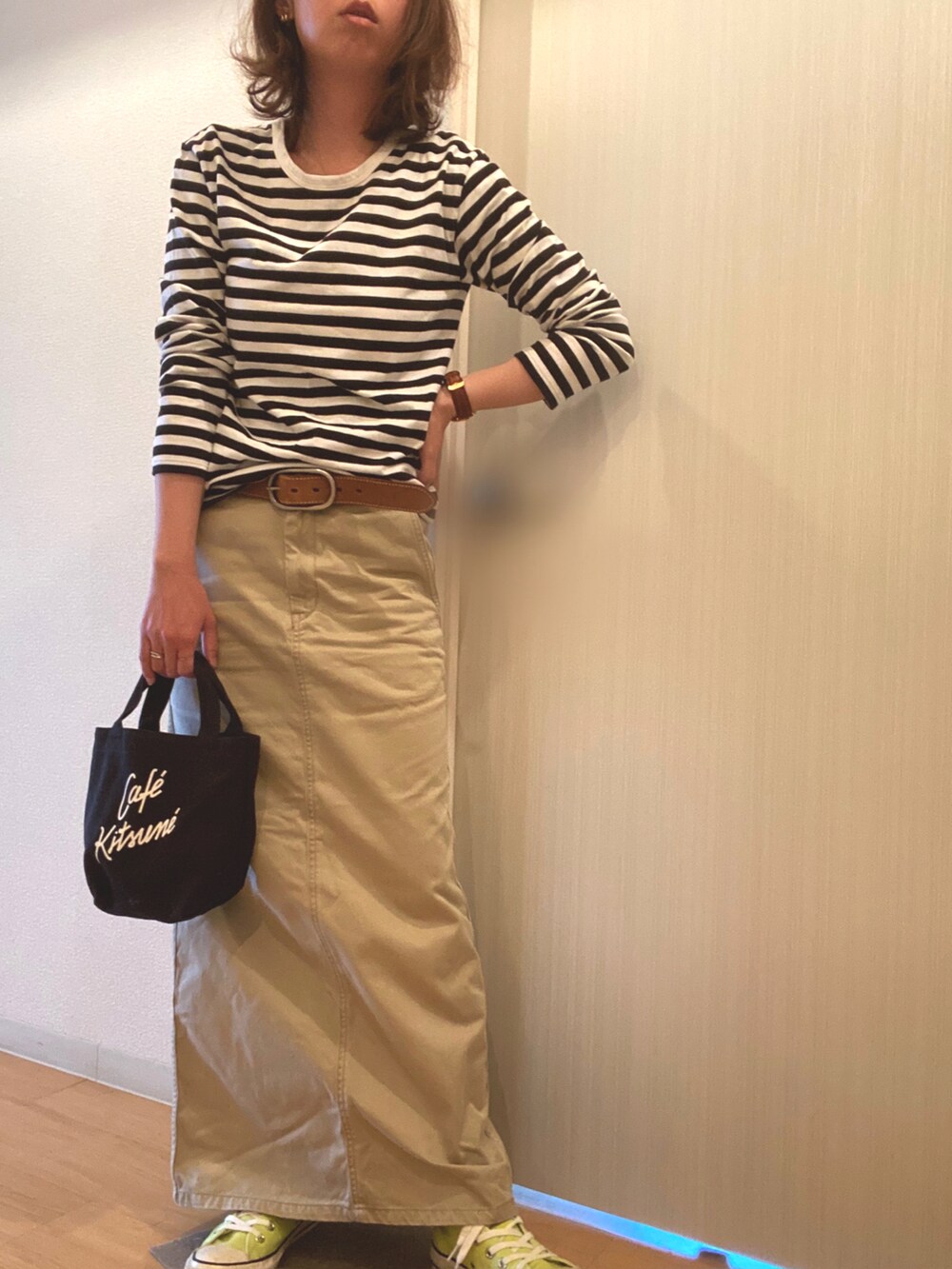 ブラック系のTシャツ/カットソー、ベージュ系のスカート、イエロー系のスニーカーを着用したレディースの春コーディネートの2枚目の写真