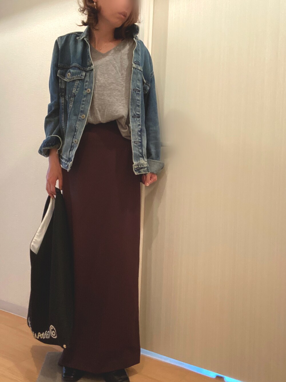 ブルー系のデニムジャケット、グレー系のニット/セーター、ブラウン系のスカートを着用したレディースの春コーディネートの2枚目の写真