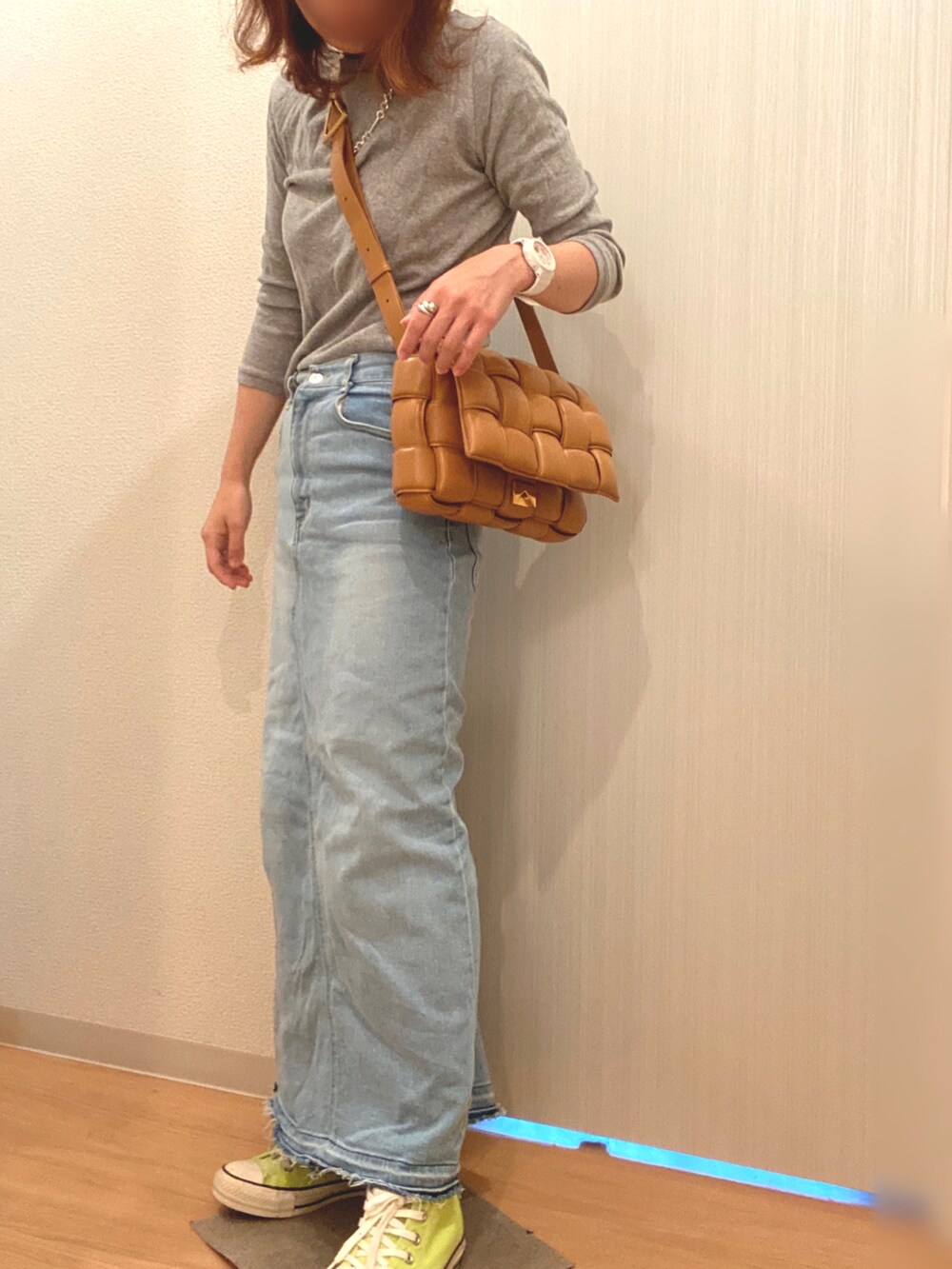 グレー系のTシャツ/カットソー、ブルー系のデニムスカート、イエロー系のスニーカーを着用したレディースの秋コーディネートの3枚目の写真