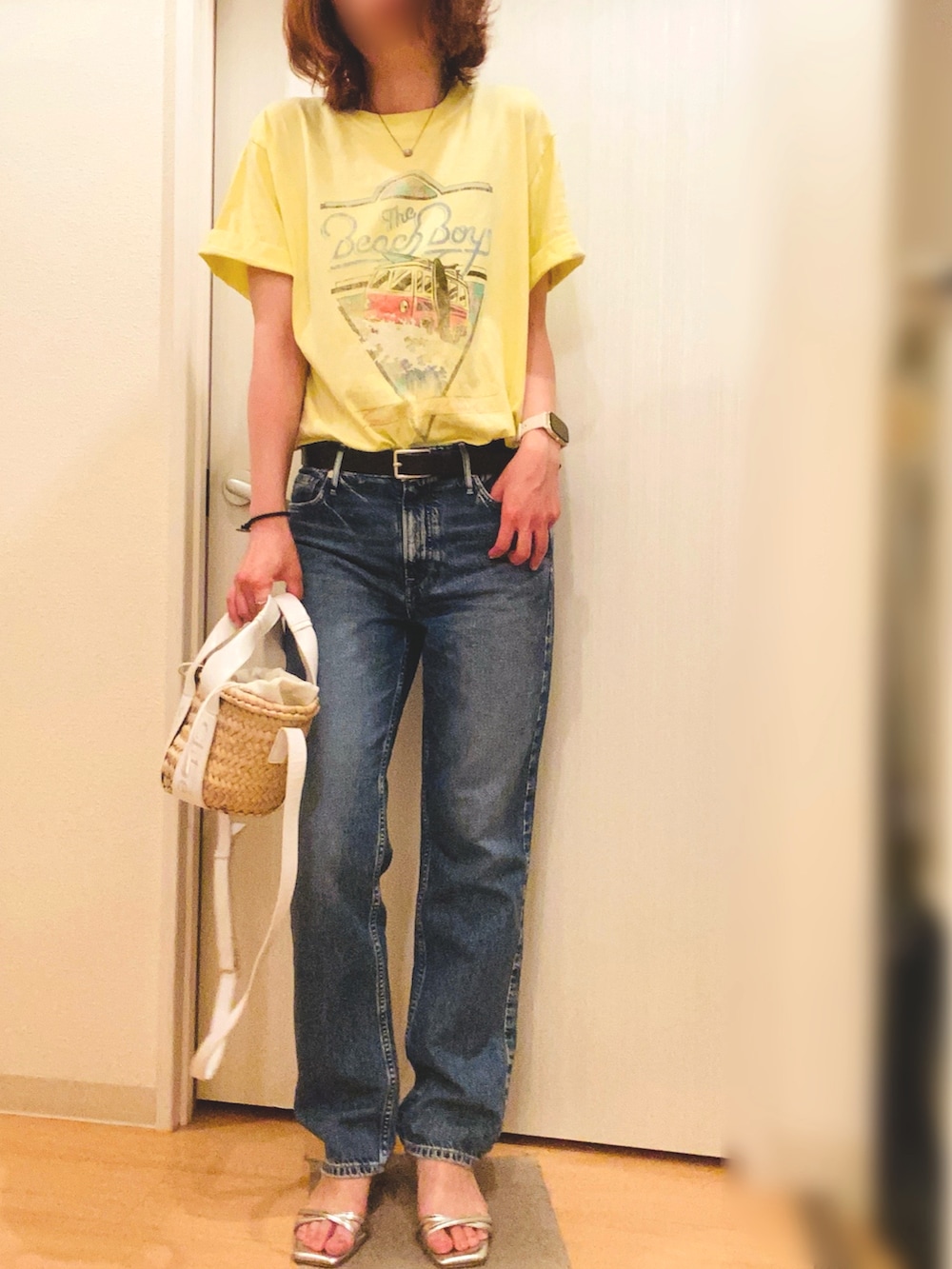 ブルー系のデニムパンツ、ベージュ系のTシャツ/カットソー、シルバー系のサンダルを着用したレディースの夏コーディネートの2枚目の写真