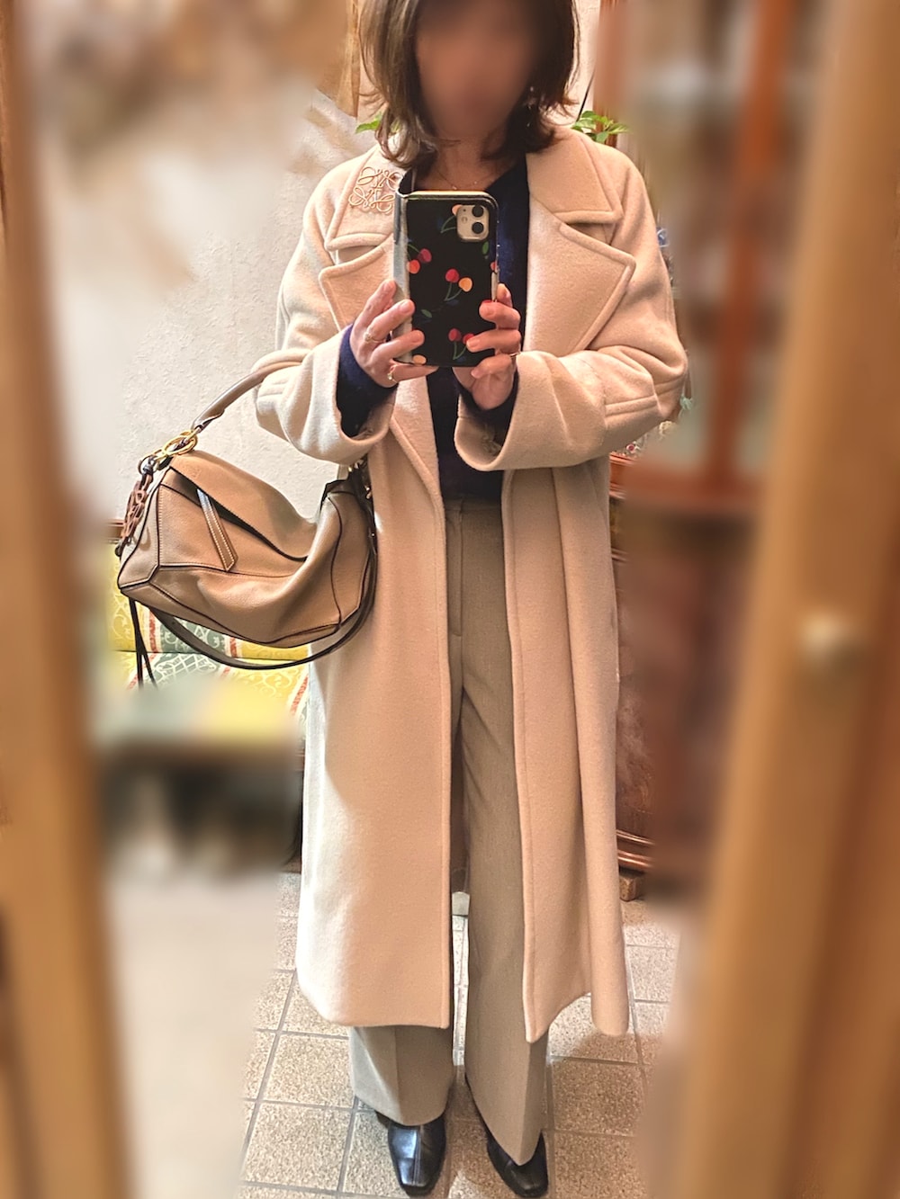 ベージュ系のその他アウター、ブルー系のニット/セーター、ベージュ系のスラックスを着用したレディースの冬コーディネートの2枚目の写真