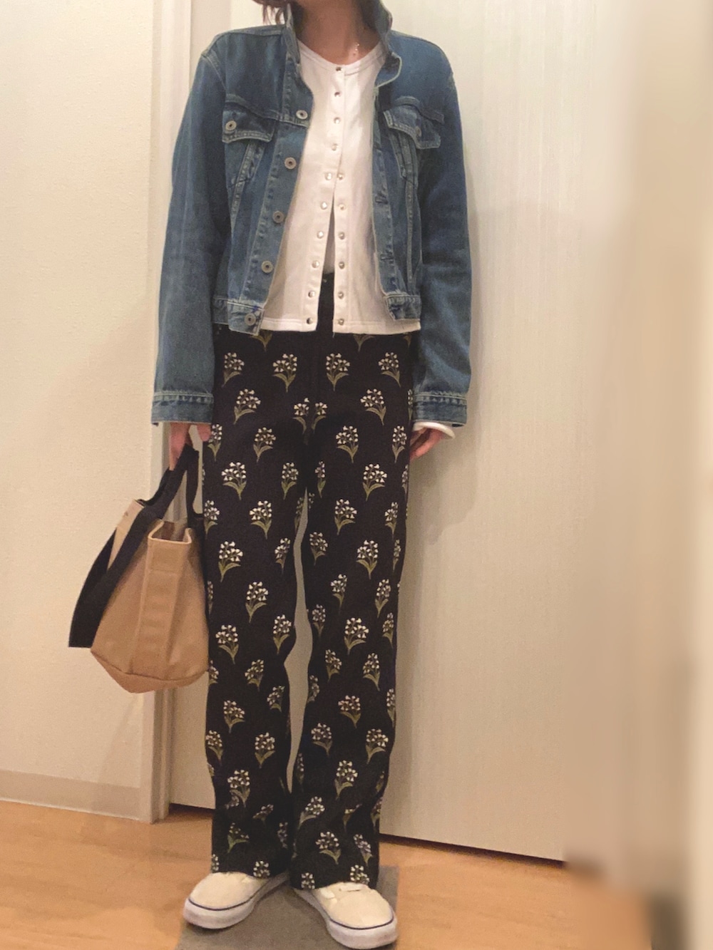 ブルー系のデニムジャケット、ホワイト系のカーディガン/ボレロ、ブラック系のその他パンツを着用したレディースの春コーディネートの2枚目の写真