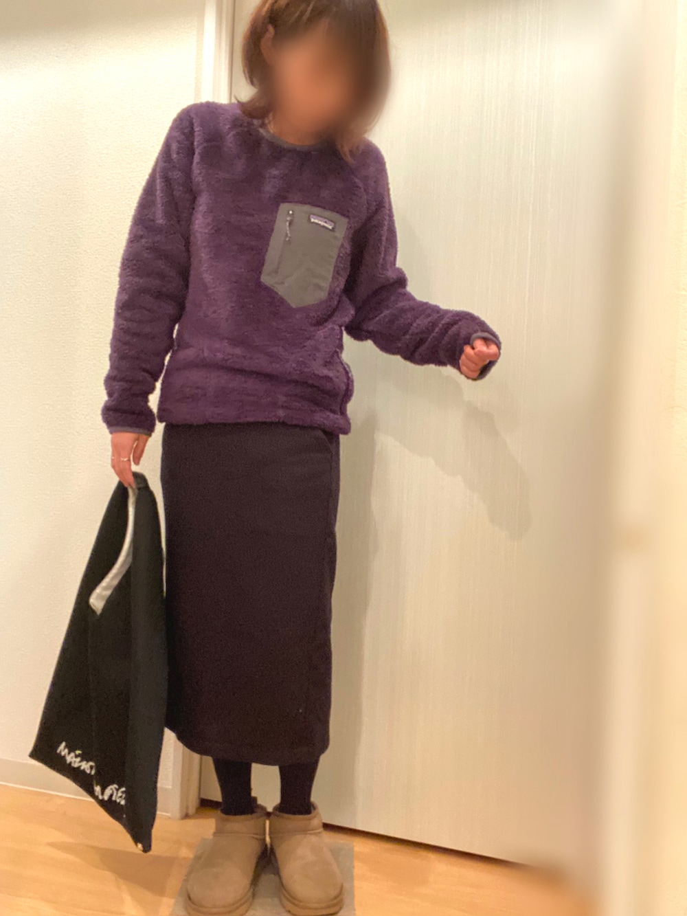 パープル系のニット/セーター、ブラック系のスカート、グリーン系のブーツを着用したレディースの冬コーディネートの2枚目の写真
