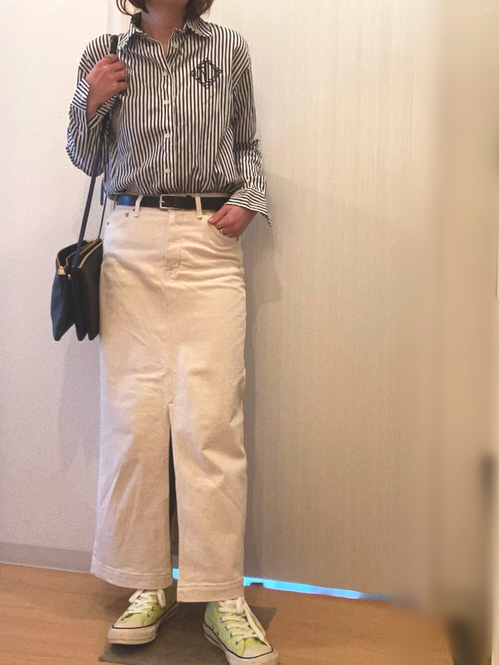 ブラック系のシャツ/ブラウス、ホワイト系のデニムスカート、イエロー系のスニーカーを着用したレディースの春コーディネートの3枚目の写真