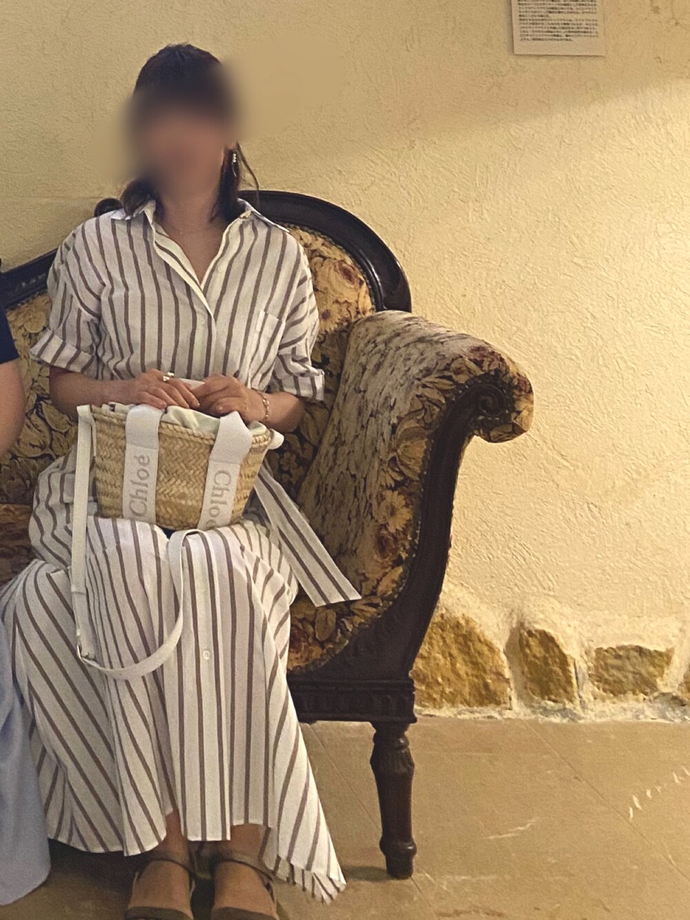 ホワイト系のワンピース、ホワイト系のかごバッグ、ベージュ系のサンダルを着用したレディースの夏コーディネートの2枚目の写真