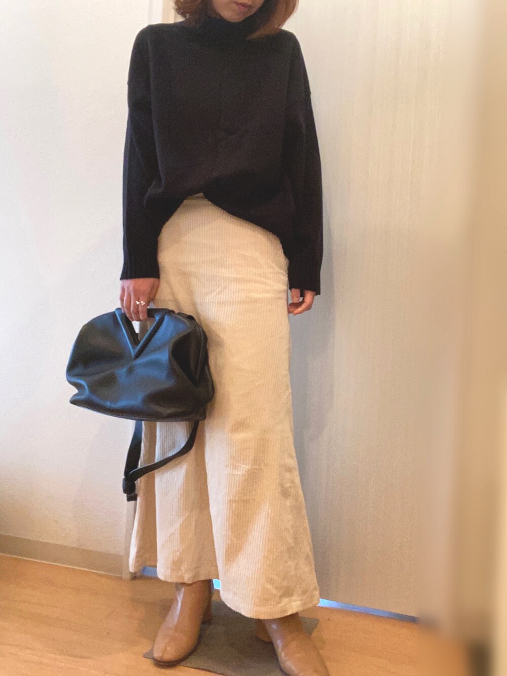 グリーン系のジャケット/アウター、ブラック系のニット/セーター、ホワイト系のスカートを着用したレディースの冬コーディネートの4枚目の写真