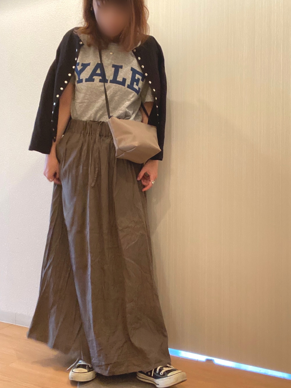 グレー系のTシャツ/カットソー、ブラウン系のスカート、ブラック系のカーディガン/ボレロを着用したレディースの秋コーディネートの3枚目の写真