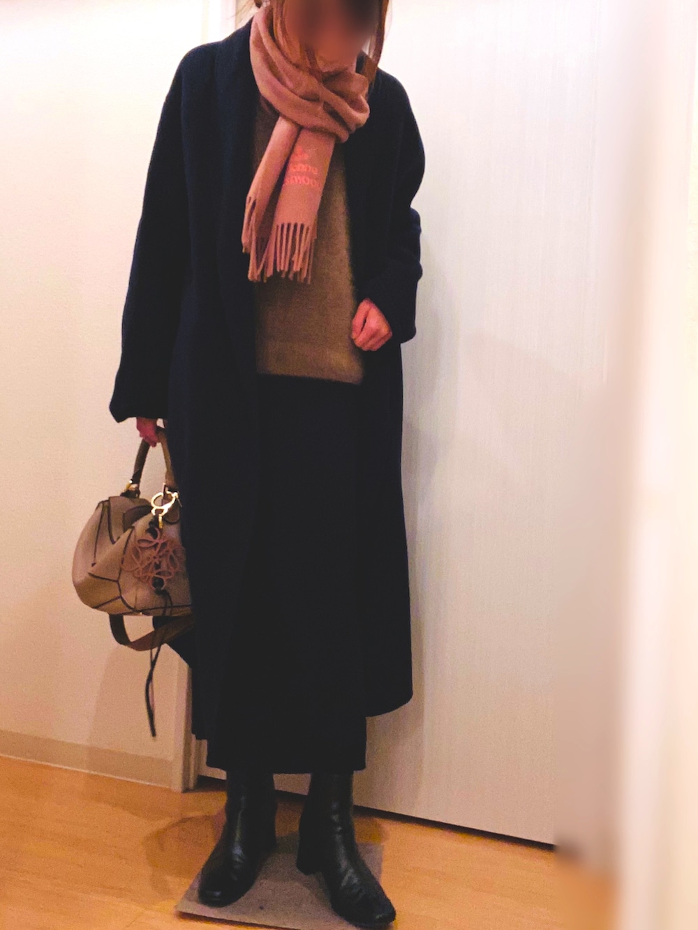 ブラウン系のニット/セーター、ブラック系のスカート、ブラック系のブーツを着用したレディースの冬コーディネートの3枚目の写真