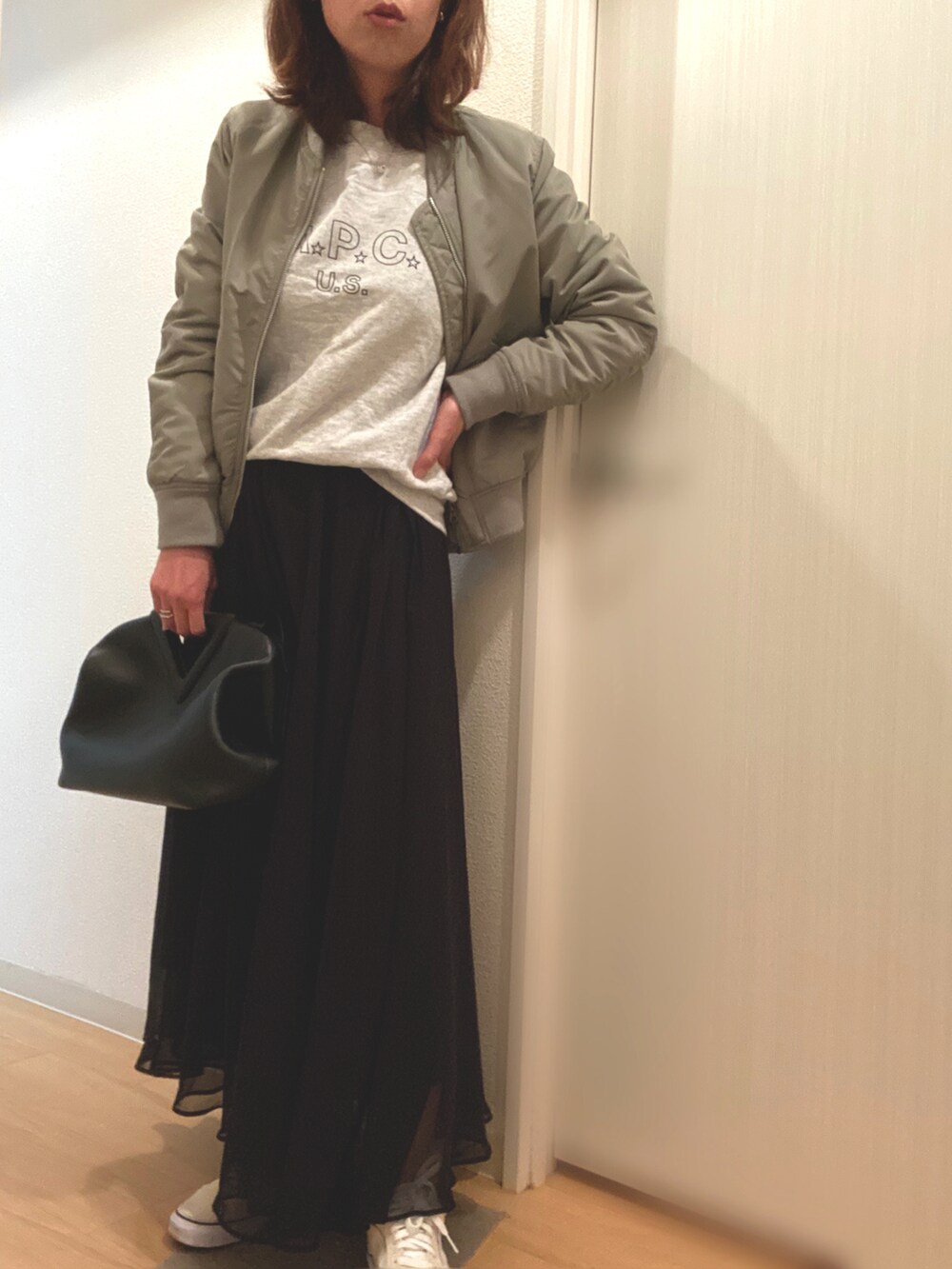グレー系のスウェット、ブラック系のスカート、グレー系のその他アウターを着用したレディースの春コーディネートの2枚目の写真