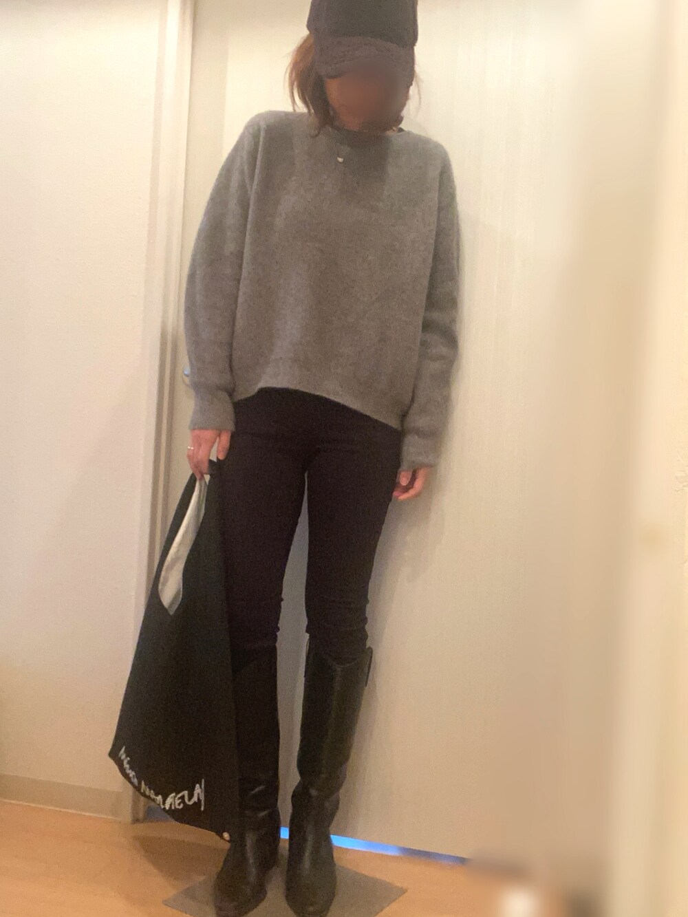 パープル系のダウンジャケット/コート、グレー系のニット/セーター、ブラック系のデニムパンツを着用したレディースの冬コーディネートの3枚目の写真