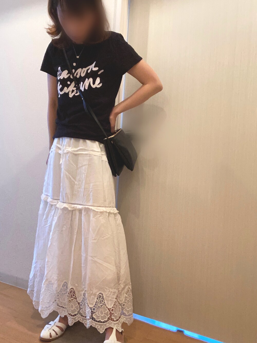 ブラック系のTシャツ/カットソー、ホワイト系のスカート、ホワイト系のサンダルを着用したレディースの夏コーディネートの2枚目の写真