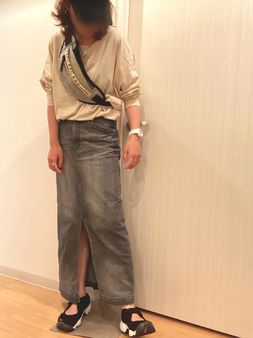 ベージュ系のTシャツ/カットソー、グレー系のデニムスカート、ブラック系のスニーカーを着用したレディースの夏コーディネートの2枚目の写真