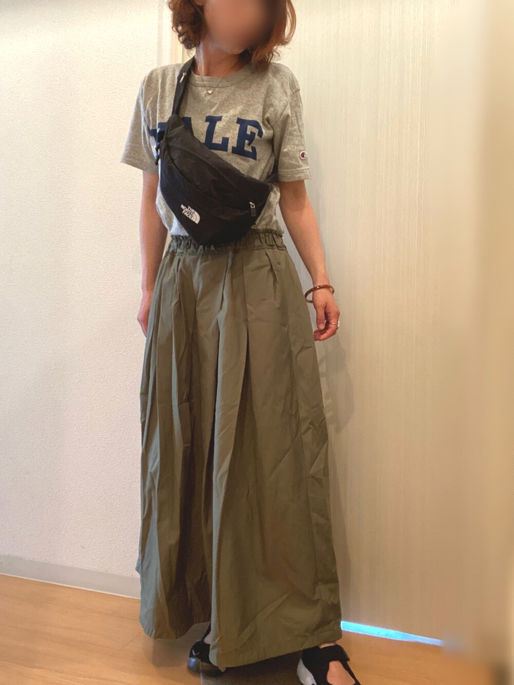 グレー系のTシャツ/カットソー、グリーン系のスカート、ブラック系のスニーカーを着用したレディースの夏コーディネートの2枚目の写真