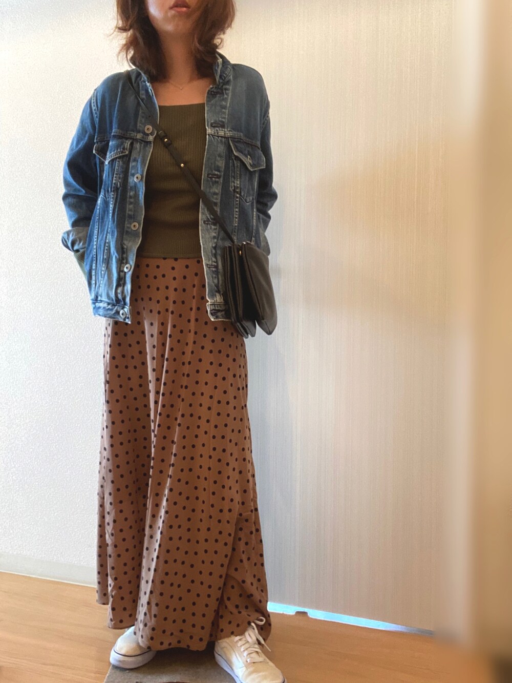 グリーン系のニット/セーター、ベージュ系のスカート、ブルー系のデニムジャケットを着用したレディースの秋コーディネートの3枚目の写真