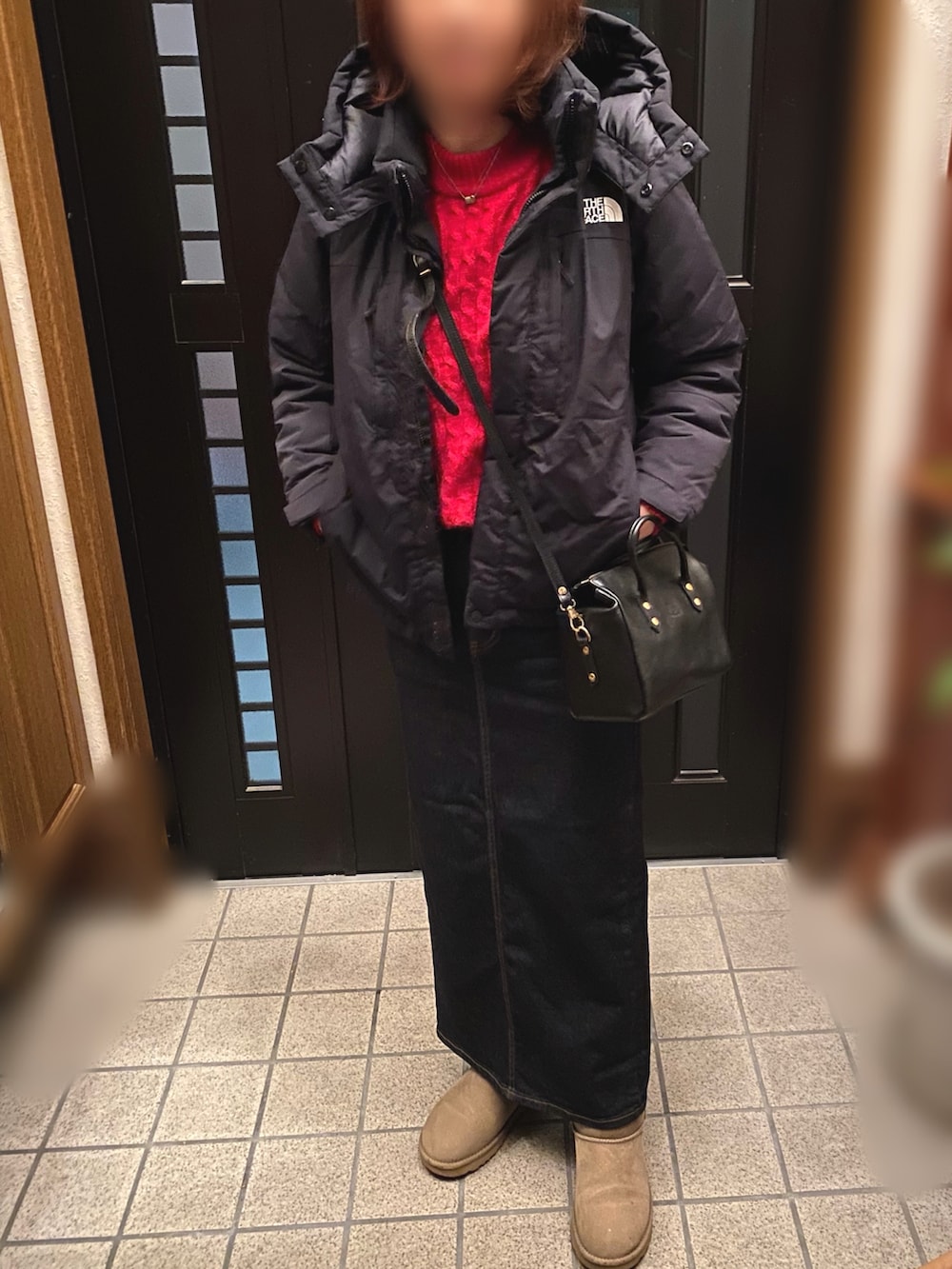 ブラック系のダウンジャケット/コート、ブルー系のデニムスカート、グリーン系のブーツを着用したレディースの冬コーディネートの2枚目の写真