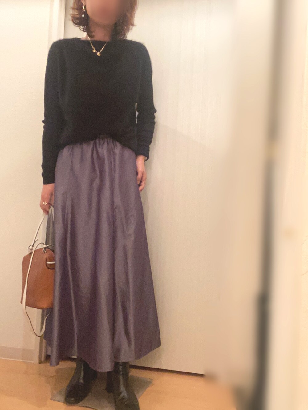 ブラック系のニット/セーター、グレー系のスカート、ベージュ系のその他アウターを着用したレディースの冬コーディネートの2枚目の写真