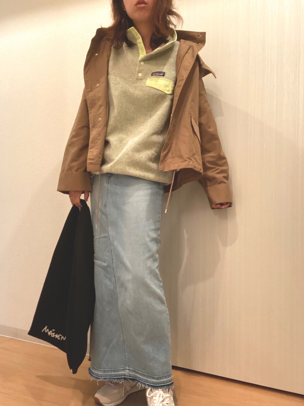 イエロー系のトップス、ブルー系のデニムスカート、ブラック系のハンドバッグを着用したレディースの秋コーディネートの4枚目の写真