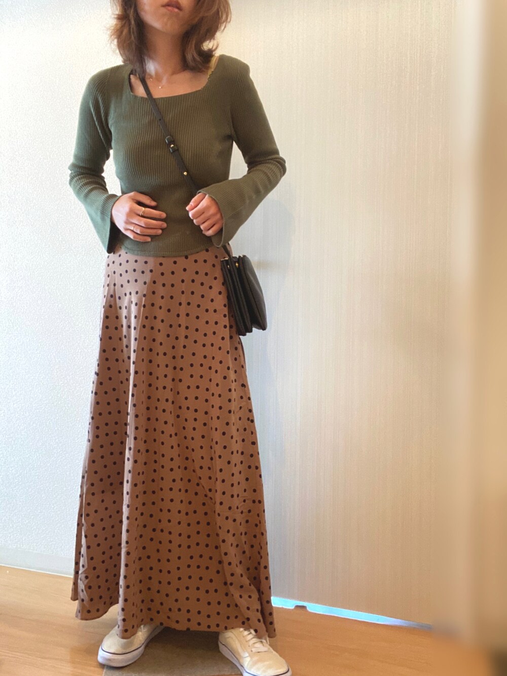 グリーン系のニット/セーター、ベージュ系のスカート、ブルー系のデニムジャケットを着用したレディースの秋コーディネートの2枚目の写真