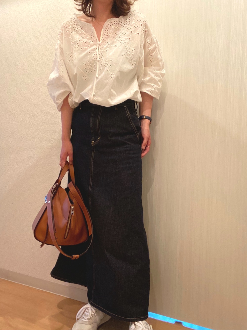 ホワイト系のシャツ/ブラウス、ブルー系のデニムスカート、グレー系のスニーカーを着用したレディースの夏コーディネートの2枚目の写真