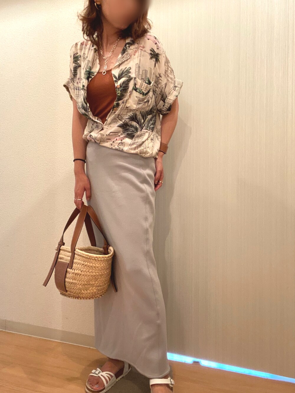 ブラウン系のタンクトップ、ブルー系のスカート、ホワイト系のサンダルを着用したレディースの夏コーディネートの2枚目の写真