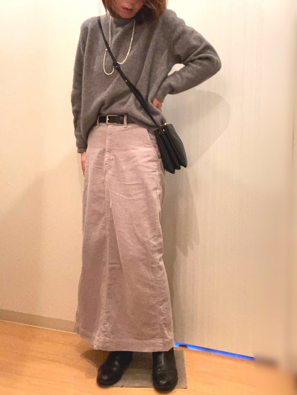 パープル系のダウンジャケット/コート、グレー系のニット/セーター、グレー系のスカートを着用したレディースの冬コーディネートの3枚目の写真