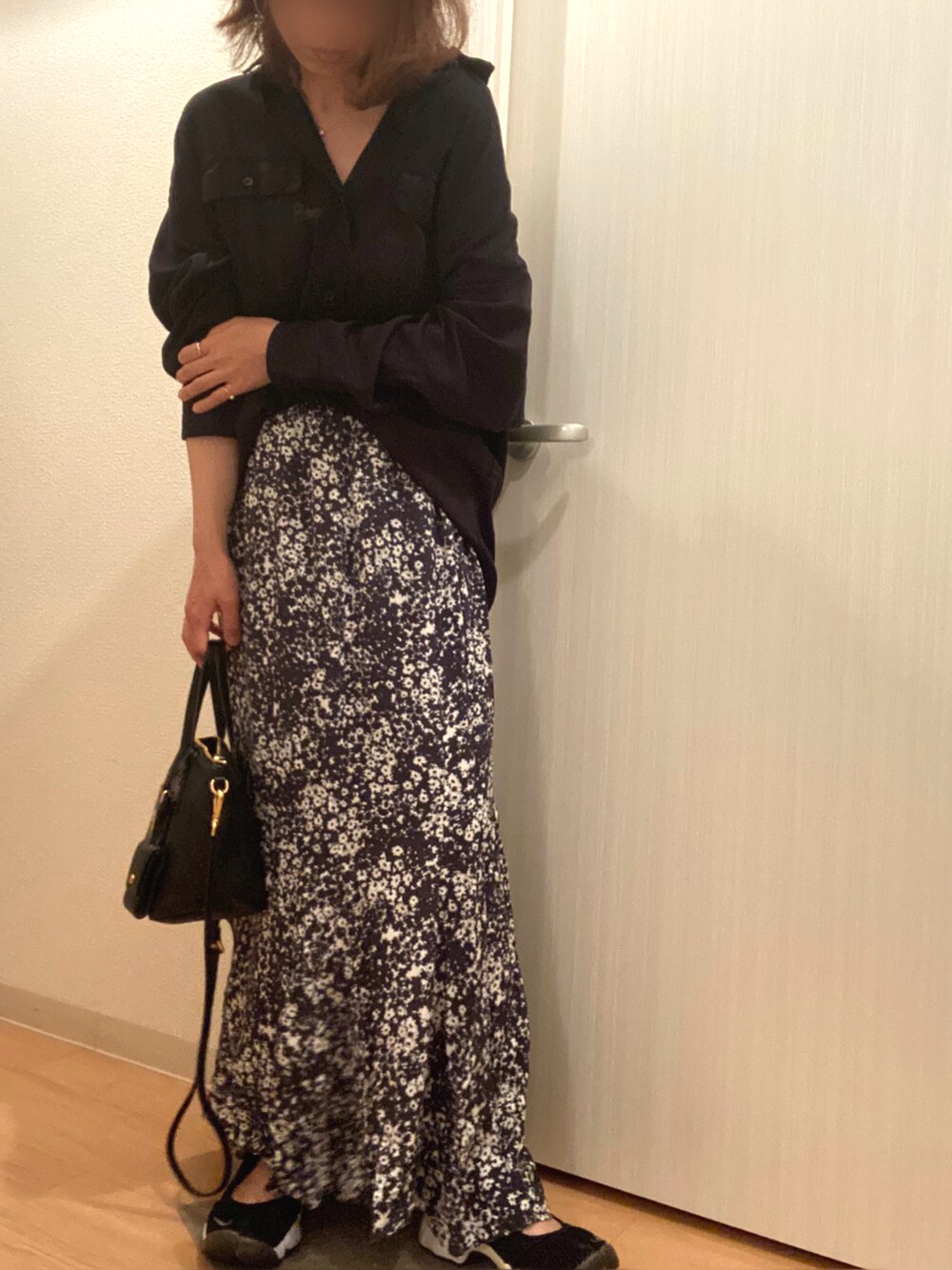 ブラック系のシャツ/ブラウス、グレー系のスカート、ブラック系のスニーカーを着用したレディースの春コーディネートの2枚目の写真